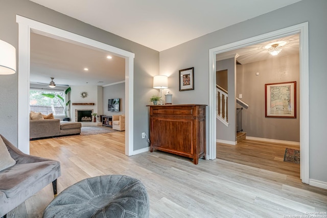 living area with ceiling fan and light wood-type flooring