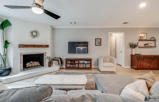 living room with crown molding, ceiling fan, and light hardwood / wood-style floors