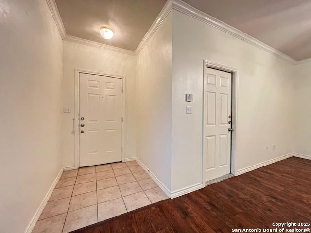 foyer featuring crown molding and light hardwood / wood-style flooring