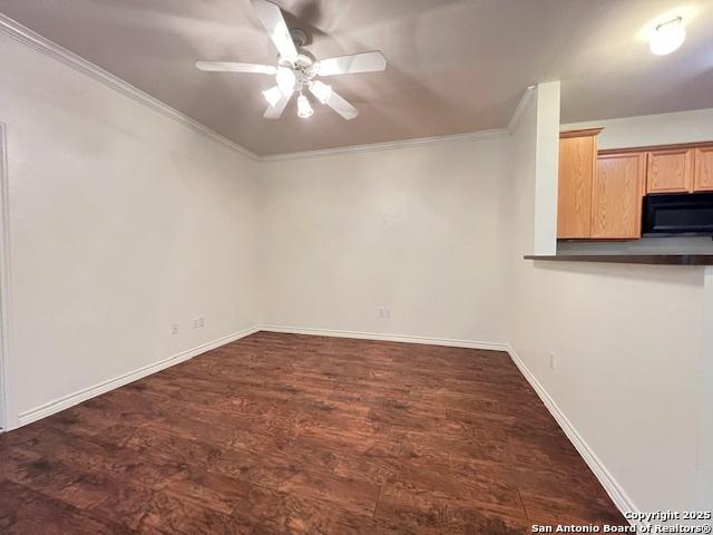 empty room with ceiling fan, ornamental molding, and dark hardwood / wood-style floors