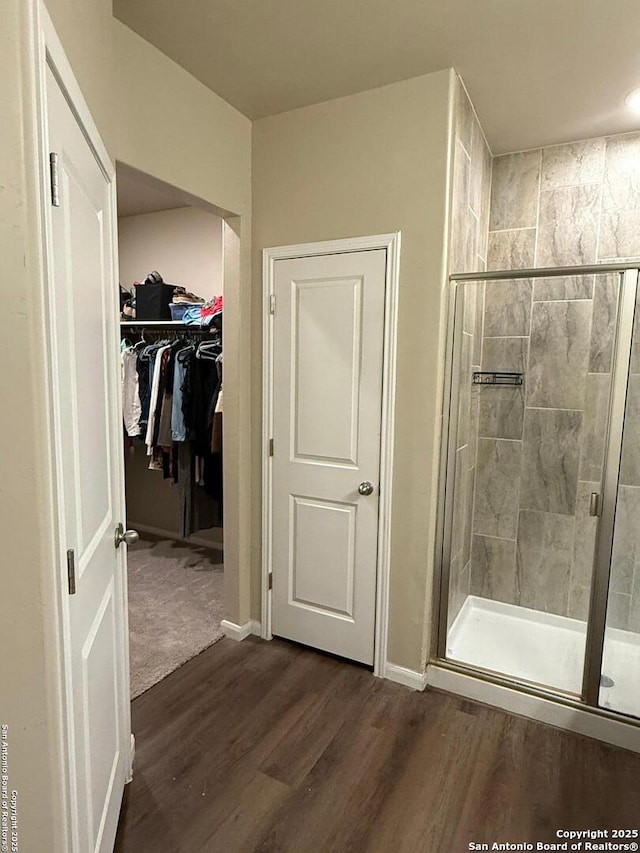 bathroom with wood-type flooring and a shower with shower door