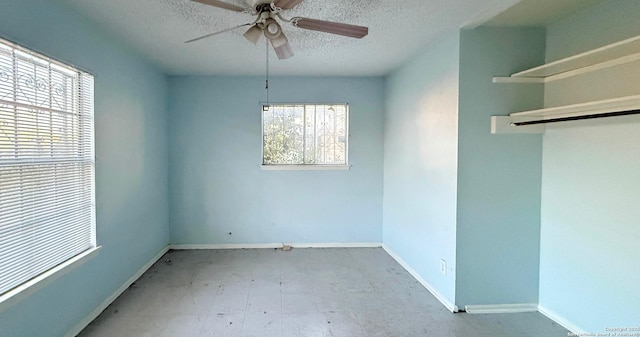 unfurnished room featuring ceiling fan and a textured ceiling