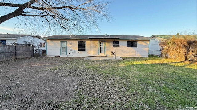 back of property featuring a patio and a lawn