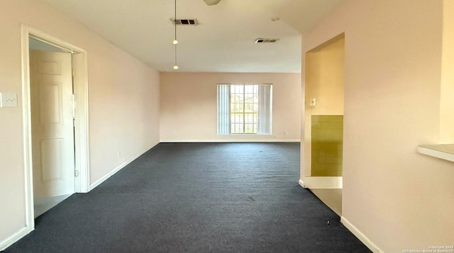 unfurnished room with dark colored carpet