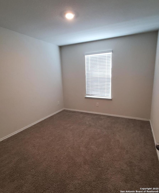 empty room with dark colored carpet