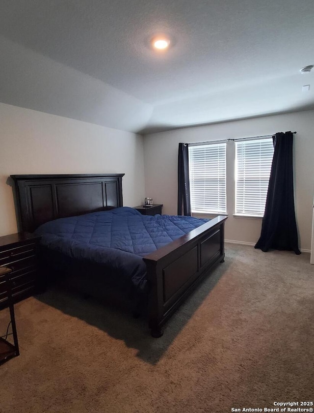 bedroom with carpet floors and vaulted ceiling