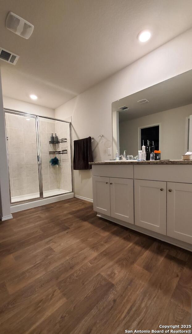 bathroom featuring vanity, hardwood / wood-style flooring, and walk in shower