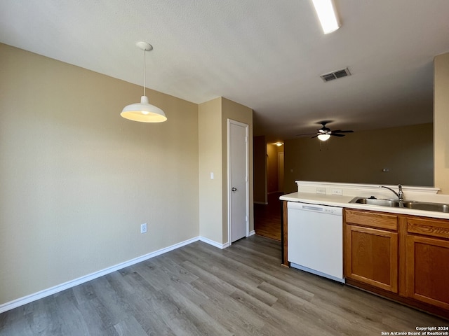 kitchen featuring sink, pendant lighting, white dishwasher, and light hardwood / wood-style flooring