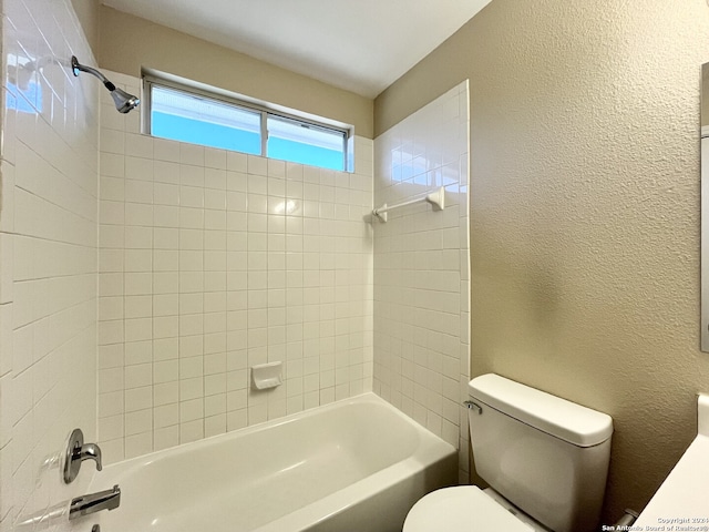 bathroom featuring tiled shower / bath and toilet