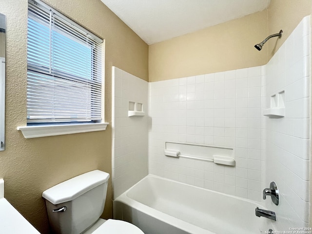 bathroom featuring tiled shower / bath and toilet