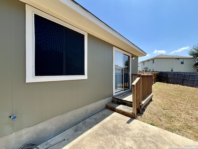 view of home's exterior with a lawn, a deck, and a patio area