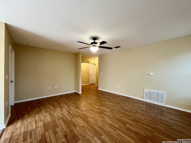 spare room featuring a textured ceiling, wood-type flooring, and ceiling fan