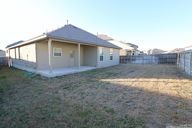 rear view of property with a patio and a lawn