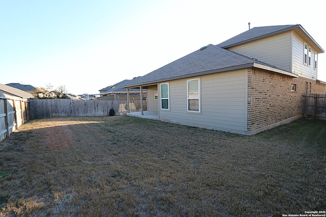 back of house featuring a patio and a lawn