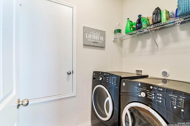 clothes washing area with washing machine and dryer