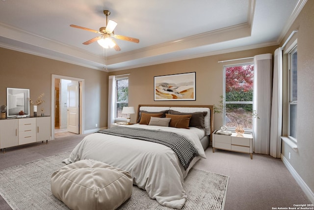 carpeted bedroom featuring crown molding, ceiling fan, and a raised ceiling