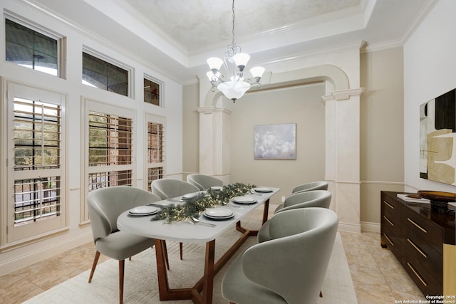 tiled dining area with ornate columns, ornamental molding, a chandelier, and a tray ceiling