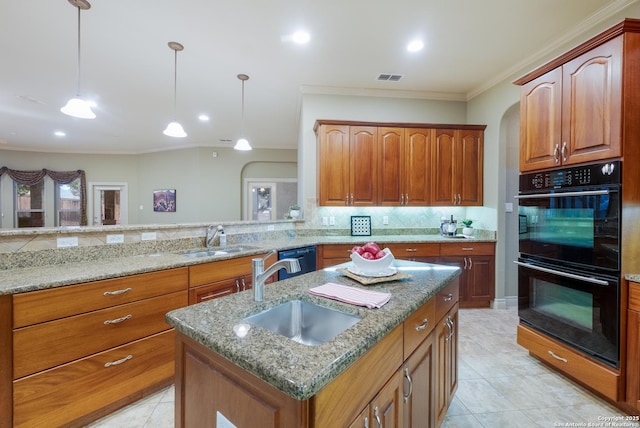 kitchen featuring a kitchen island with sink, sink, black appliances, and hanging light fixtures