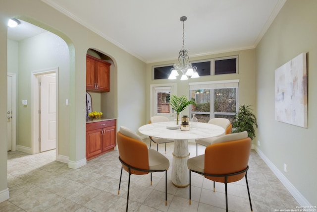 dining area featuring crown molding, light tile patterned floors, and an inviting chandelier