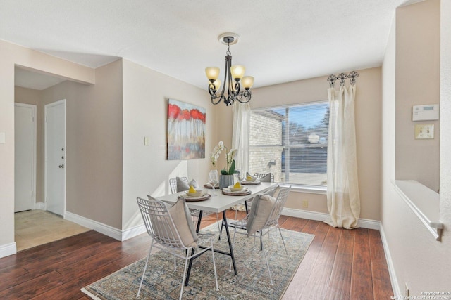 dining space featuring a notable chandelier and dark wood-type flooring