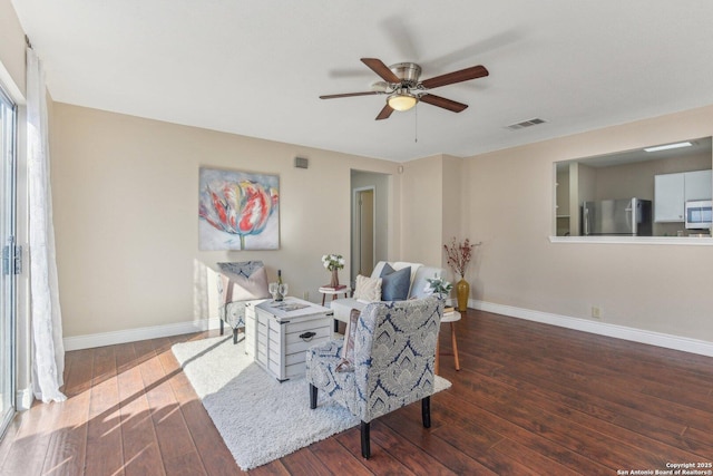 living room with dark wood-type flooring and ceiling fan