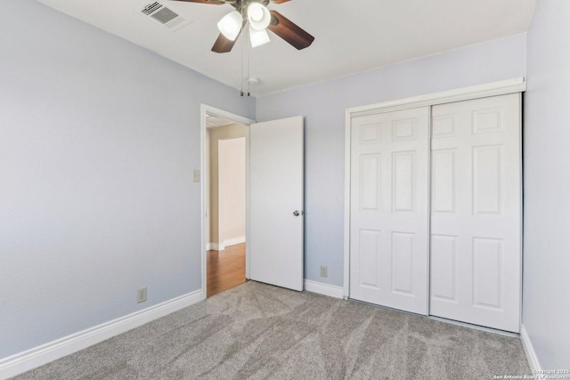 unfurnished bedroom featuring ceiling fan, a closet, and light carpet