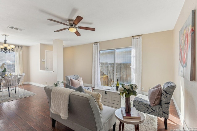 sitting room featuring ceiling fan with notable chandelier and dark hardwood / wood-style floors