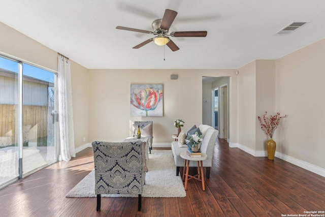 living area featuring dark wood-type flooring and ceiling fan