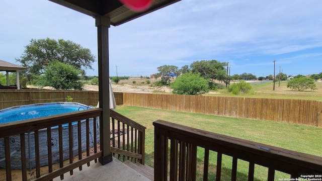 wooden deck featuring a fenced in pool and a lawn