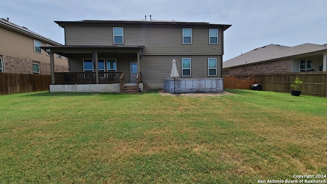 rear view of property featuring a lawn