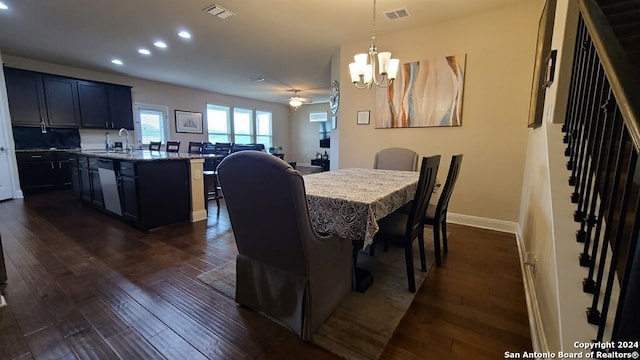 dining room with sink, a notable chandelier, and dark wood-type flooring