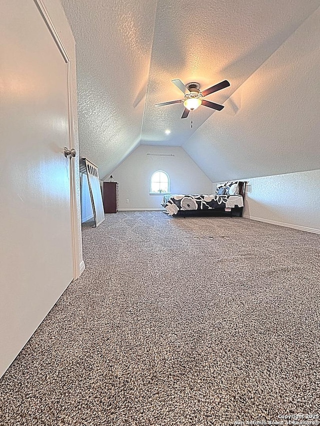 additional living space featuring ceiling fan, carpet floors, a textured ceiling, and vaulted ceiling