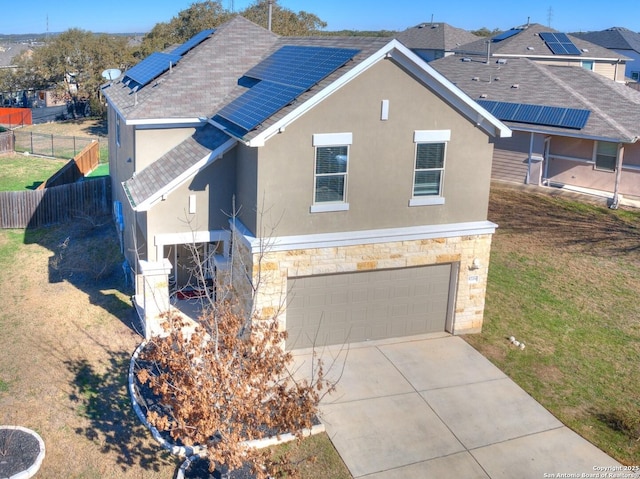 view of front of property featuring a garage and solar panels