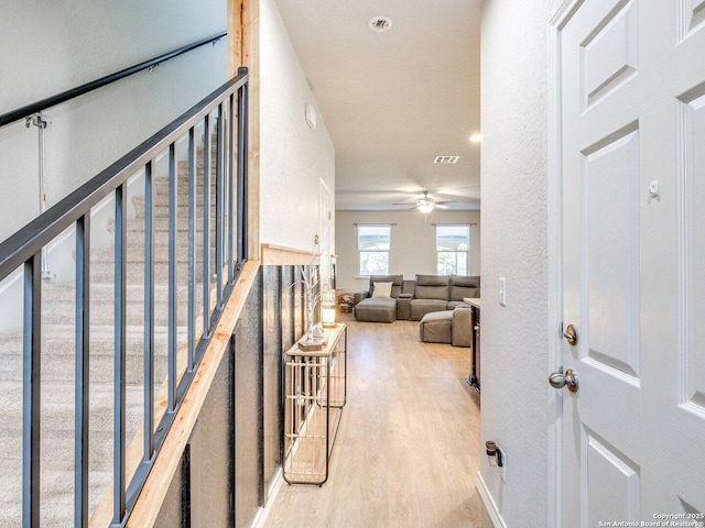 stairs featuring hardwood / wood-style floors and ceiling fan