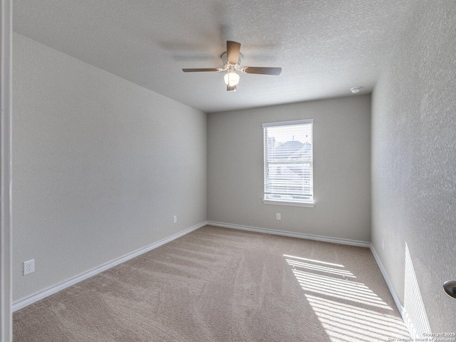 unfurnished room featuring ceiling fan, light carpet, and a textured ceiling