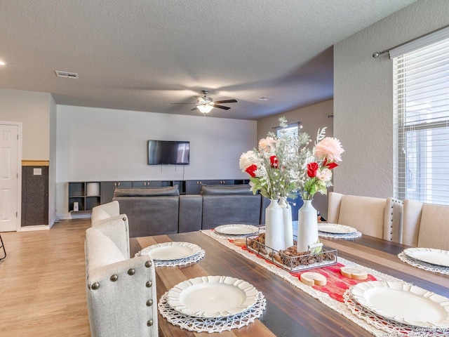 dining room featuring ceiling fan, a textured ceiling, and light wood-type flooring