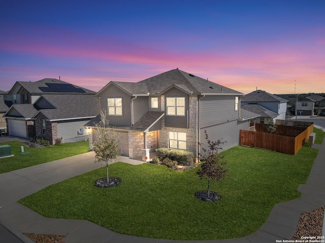 view of front of house with a garage and a yard