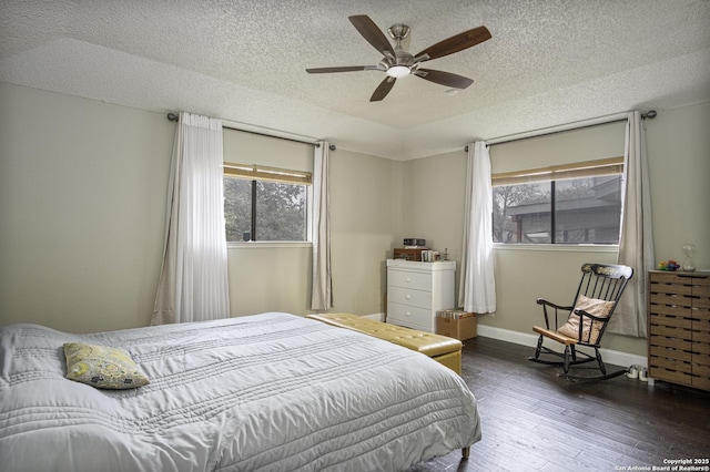 bedroom with ceiling fan, a textured ceiling, and dark hardwood / wood-style flooring