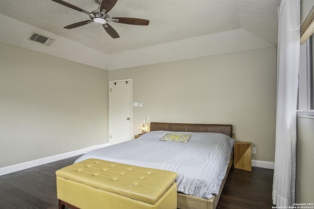 bedroom featuring ceiling fan, dark hardwood / wood-style floors, and a textured ceiling