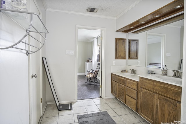 bathroom with ornamental molding, tile patterned flooring, a textured ceiling, and vanity