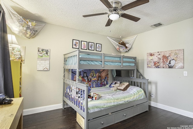 bedroom with ceiling fan, dark hardwood / wood-style floors, and a textured ceiling