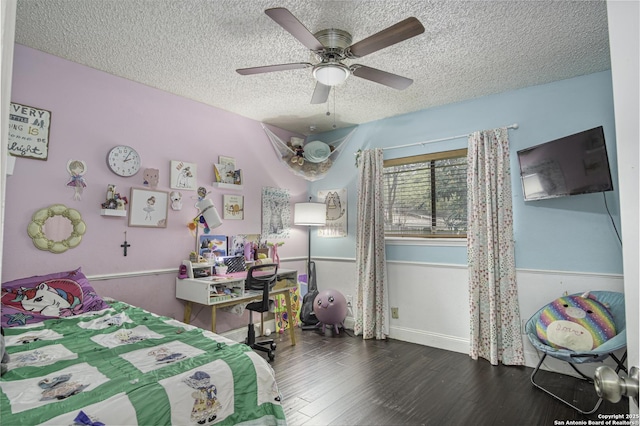 bedroom featuring dark wood-type flooring, ceiling fan, and a textured ceiling