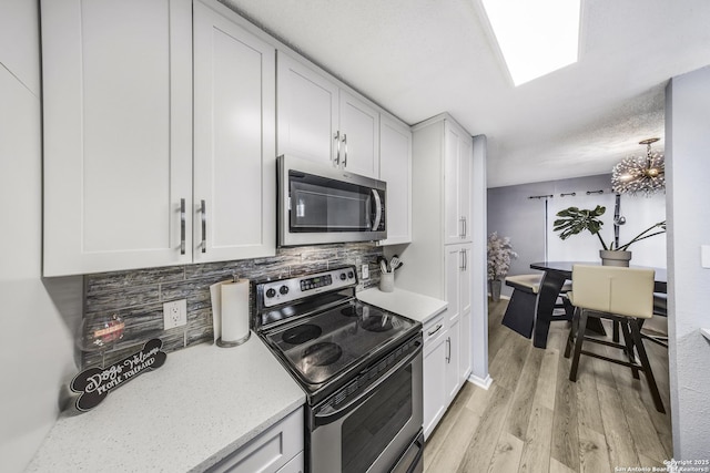 kitchen featuring white cabinetry, appliances with stainless steel finishes, and light hardwood / wood-style floors