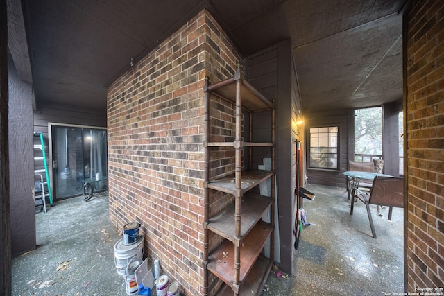 hallway featuring brick wall