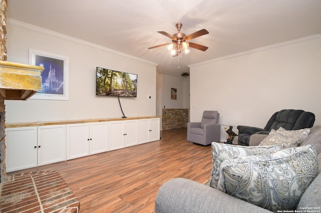 living room featuring crown molding, ceiling fan, and light hardwood / wood-style floors