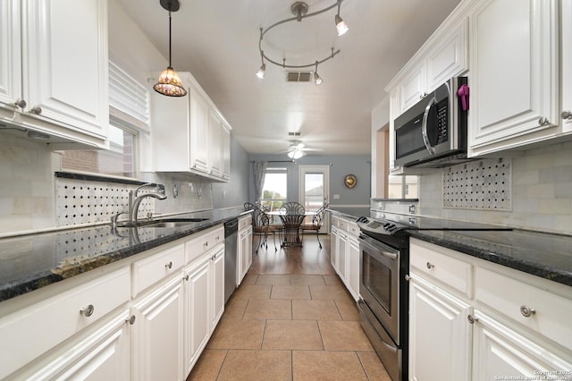 kitchen with white cabinetry, appliances with stainless steel finishes, sink, and dark stone counters