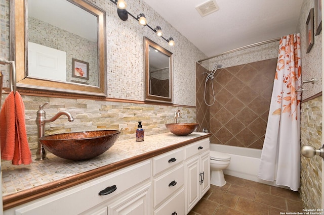 full bathroom featuring tasteful backsplash, vanity, shower / tub combo, toilet, and tile patterned floors