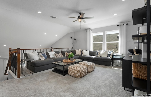 carpeted living room with ceiling fan and vaulted ceiling