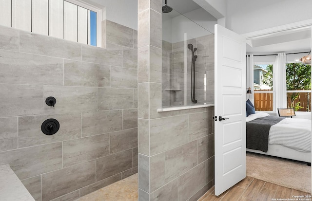 bathroom with hardwood / wood-style flooring and tiled shower