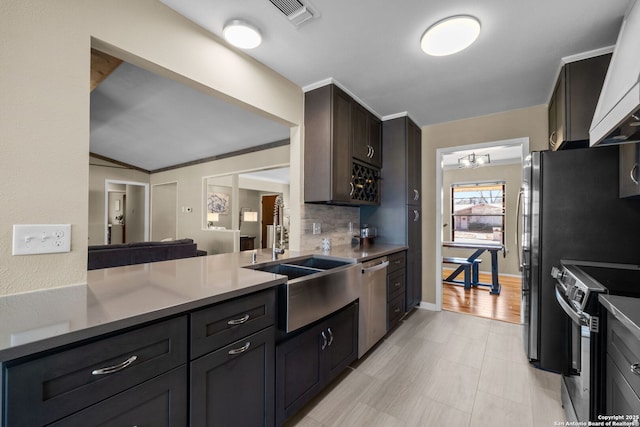 kitchen with sink, appliances with stainless steel finishes, backsplash, custom range hood, and a chandelier